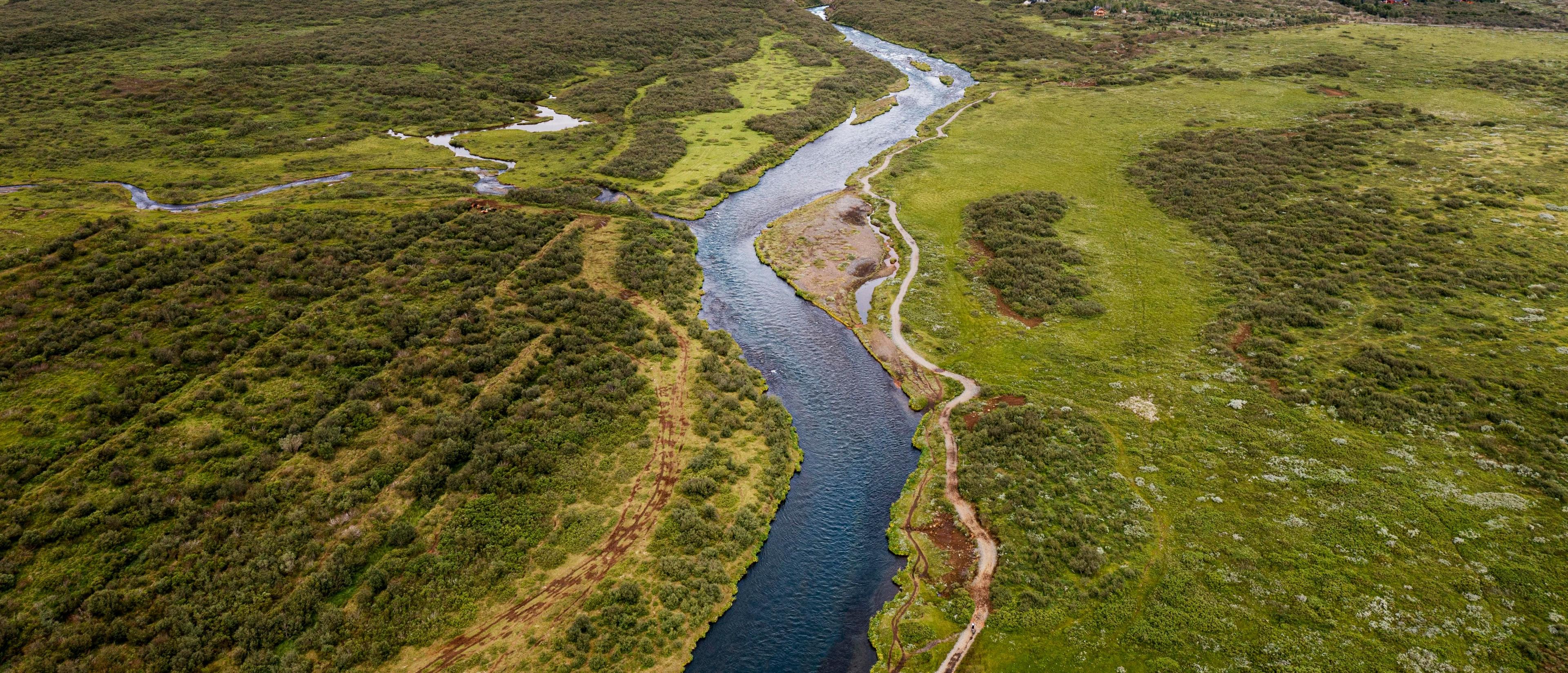Paisaje verde con un río y montañas